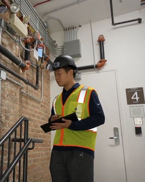 A superintendent wearing the helmet reviews the report on a tablet
